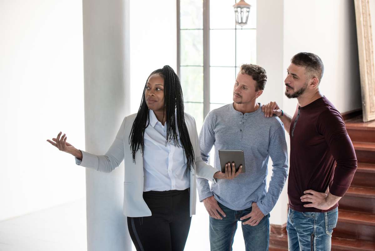 Woman real estate agent showing a house to two men