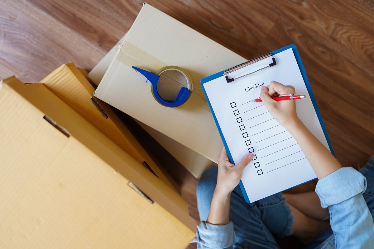 A woman filling in a checklist on moving boxes in Seattle