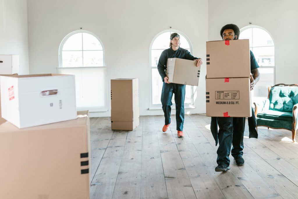 Two movers carrying cardboard boxes